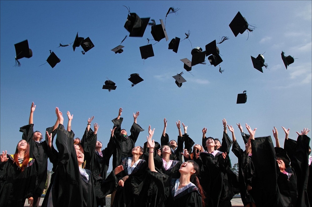 Universitari mentre lanciano in alto il cappello